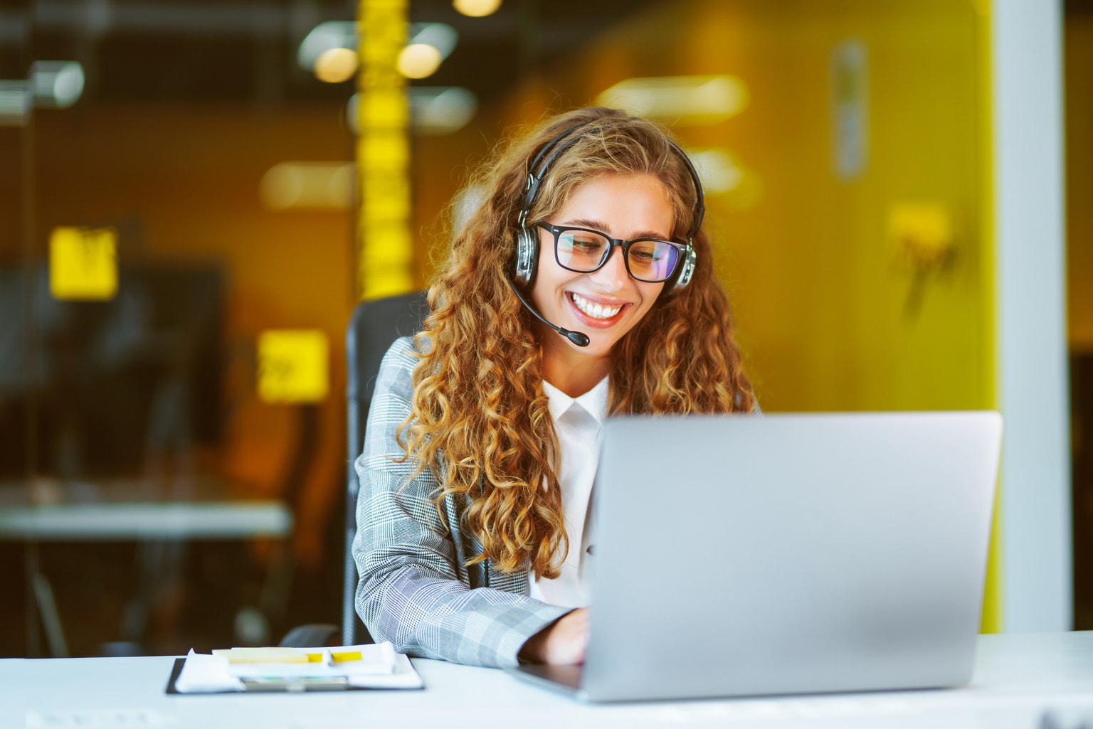 B2B Kontakt aufnehmen, Frau mit Headset telefoniert