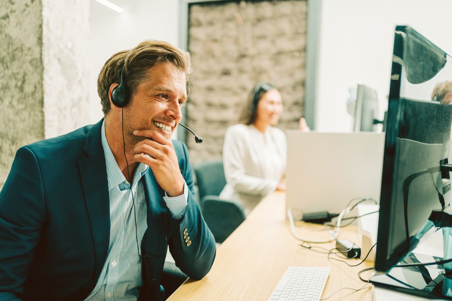 Business Telefon - Mann telefoniert mit Headset mit seinen Kunden
