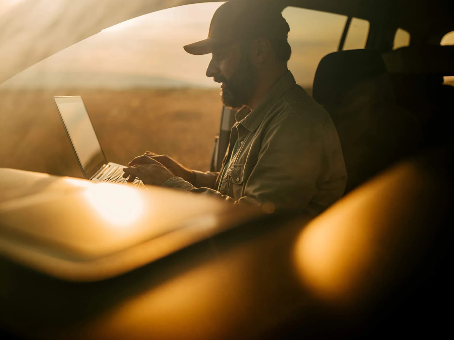 Deutsche Glasfaser Man sitzt im Auto und schaut auf seinen Laptop Bandbreite