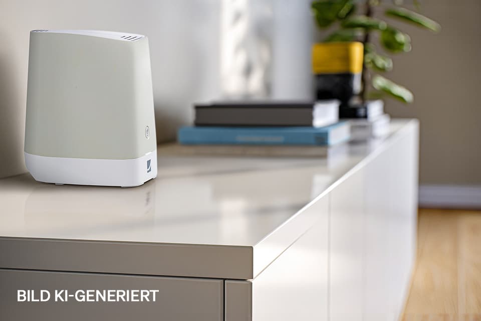Weißer Router auf weißem Sideboard mit Büchern und Zimmerpflanze im Hintergrund in modernem Wohnraum.