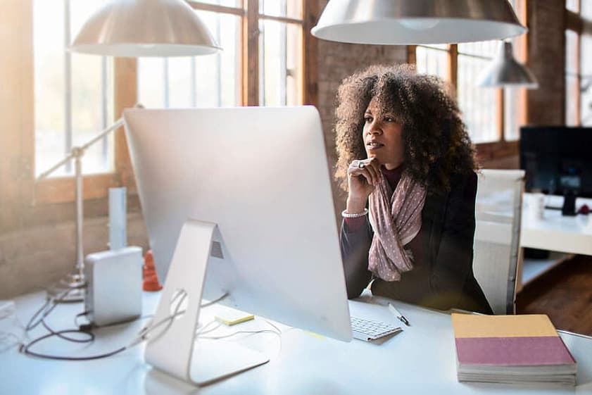 B2B Router Plus - Frau sitzt im Büro und arbeitet an