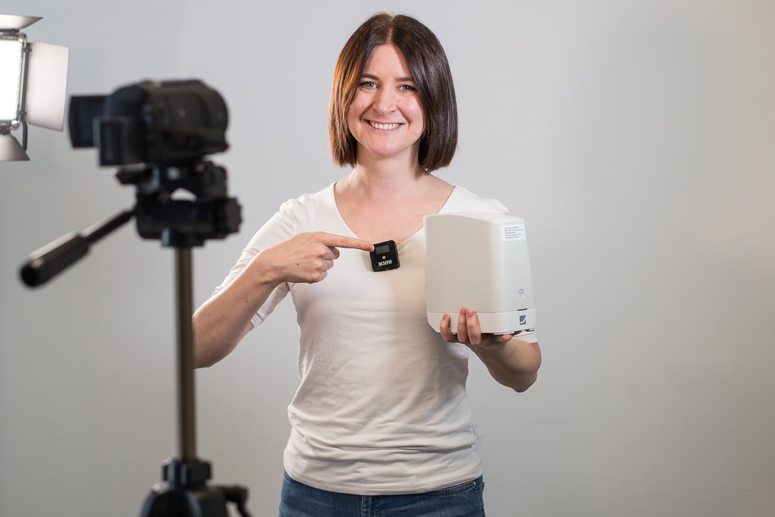 Das Bild zeigt eine Mitarbeiterin, die einen Router in der Hand hält und präsentiert.