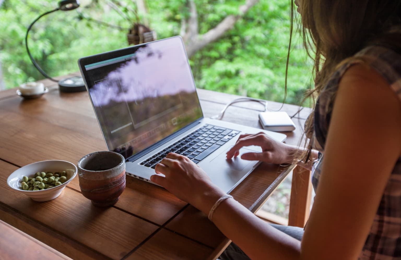 Frau sitzt am Laptop - Rechnung pünktlich und papierschonen online erhalten