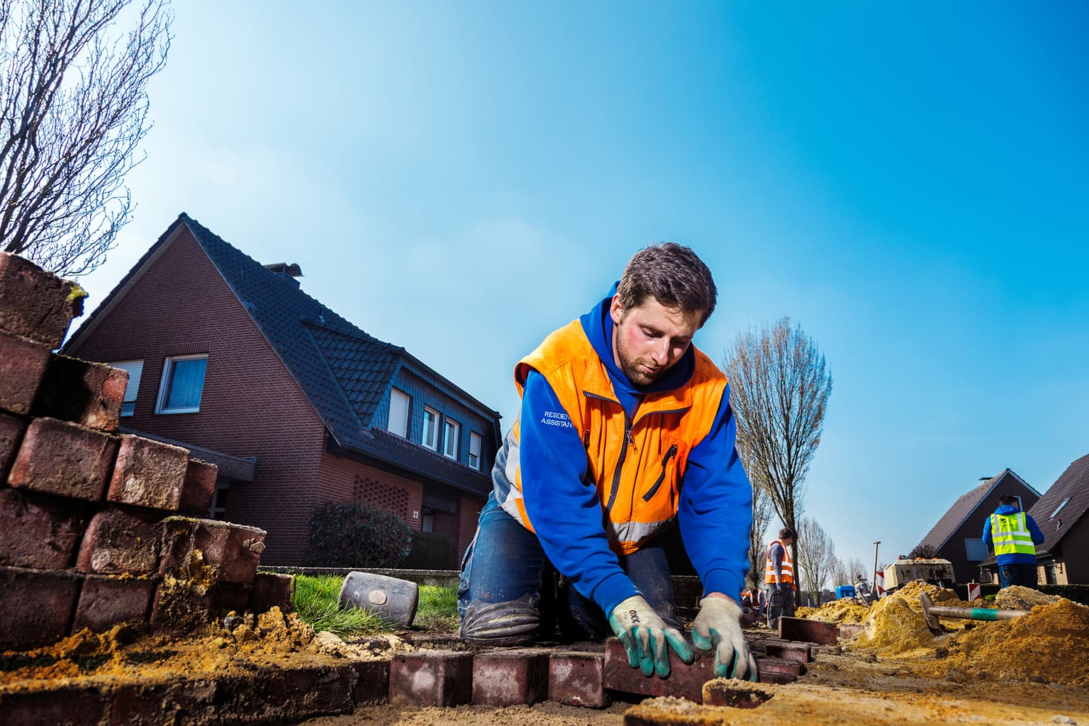 Bauphase im Überblick - Bauarbeiter verlegt Glasfaser und versiegelt die Straße 2