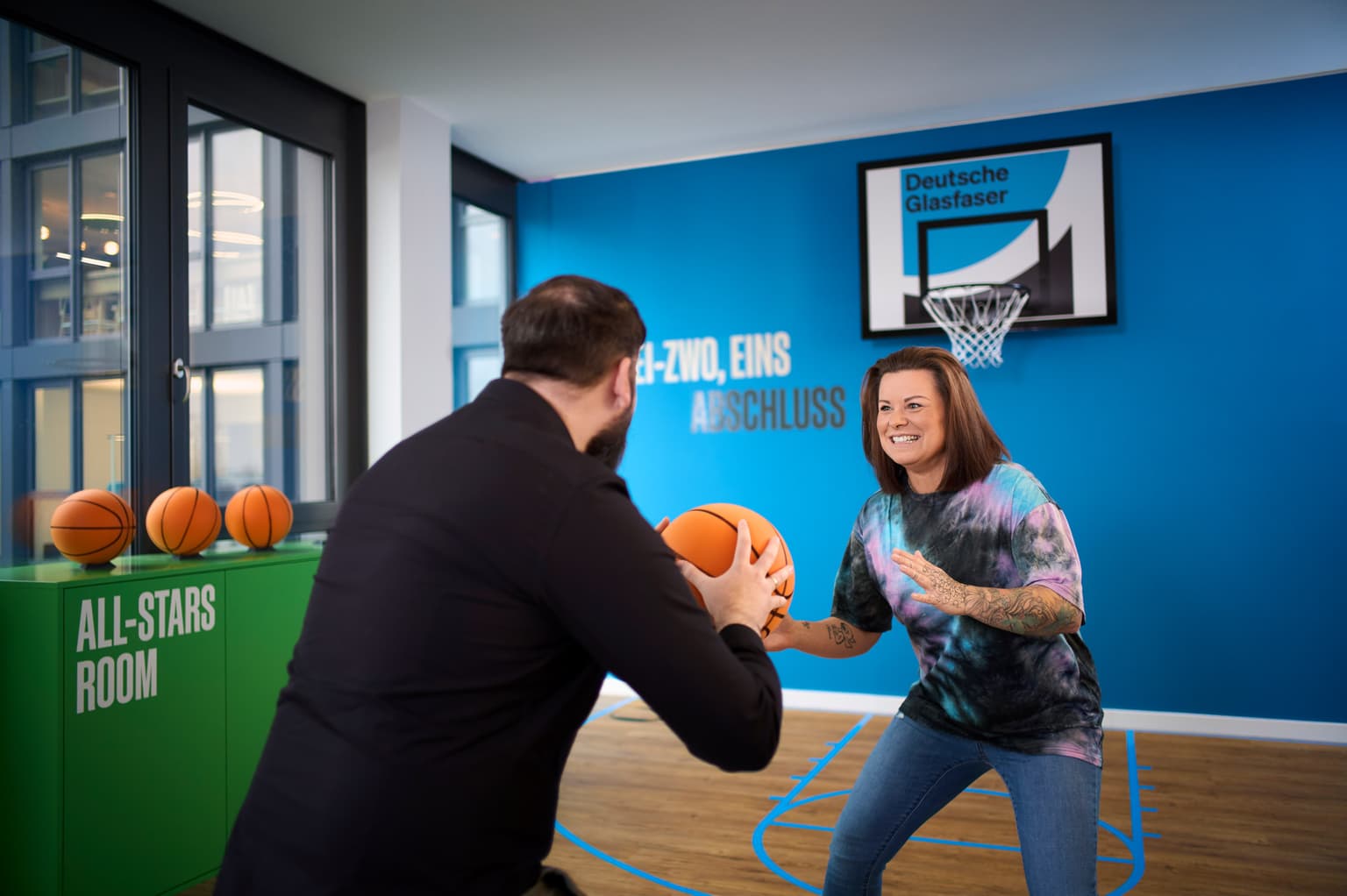 Deutsche Glasfaser Gesundheit. Mitarbeiter beim Basketball spielen
