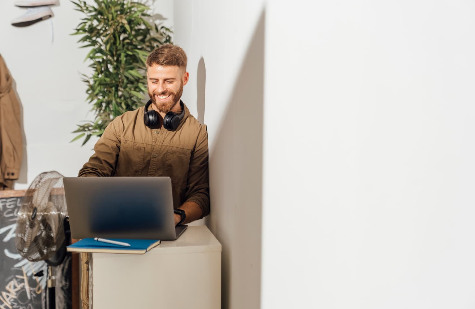 Junger Mann mit Kopfhörern surft im Internet und sucht nach der Service Seite