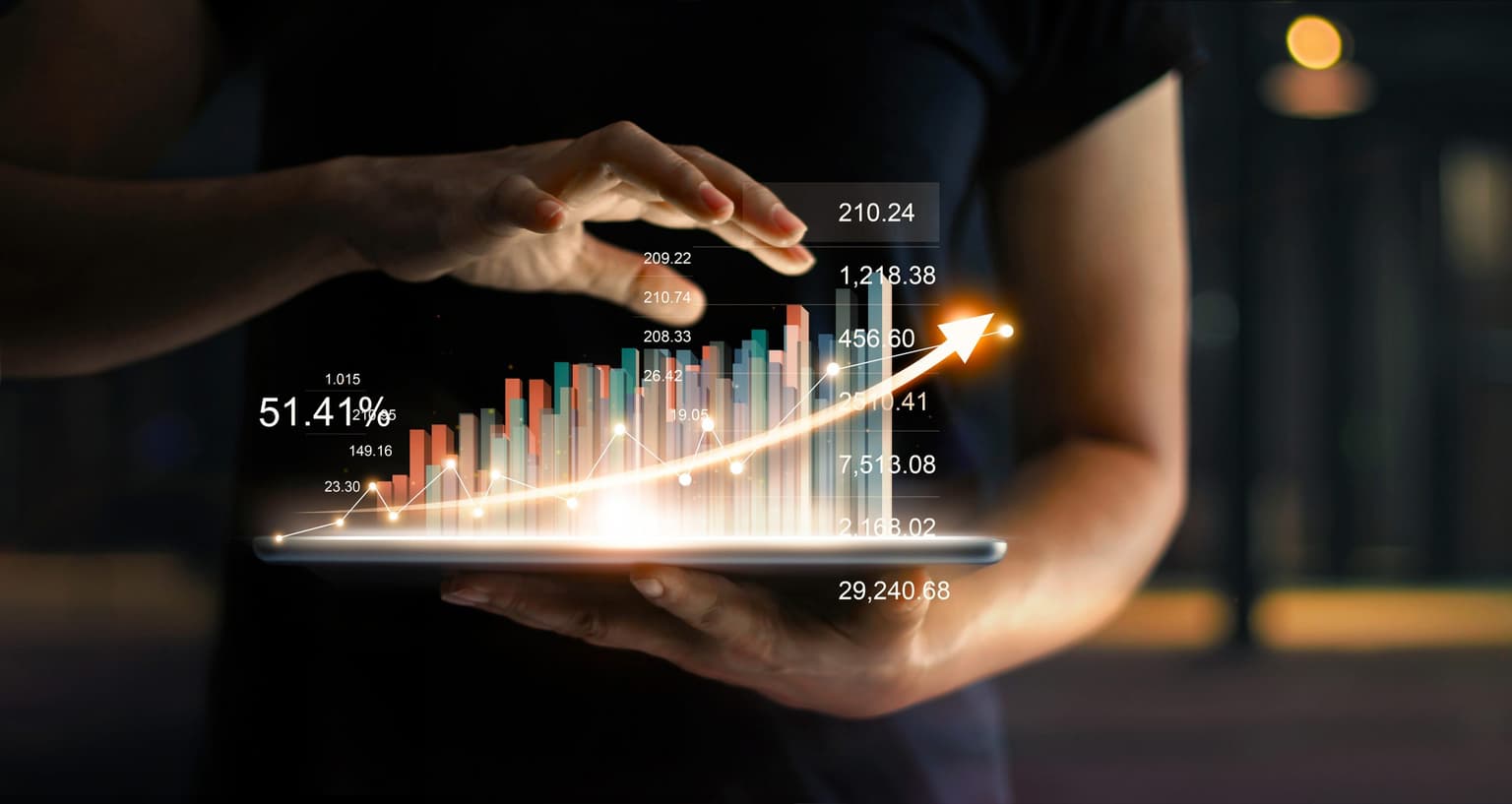 Hände halten Tablet mit holografischen Finanzdiagrammen und steigenden Aktienkursen, die einen positiven Wachstumstrend zeigen.