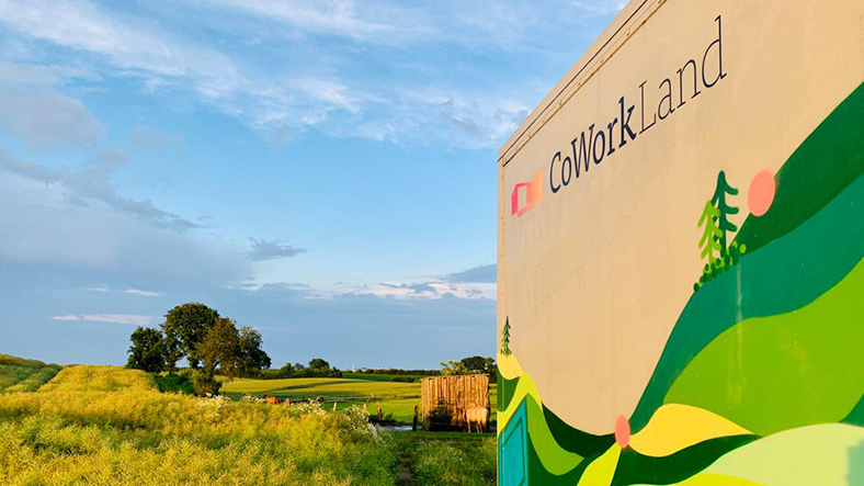 Eine Tafel mit der Aufschrift „Coworkland“ steht auf einem Feld