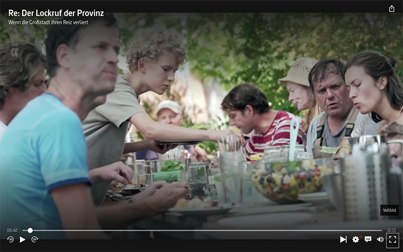 Szene aus dem Film: Familie auf dem Land sitzt am Tisch im Freien