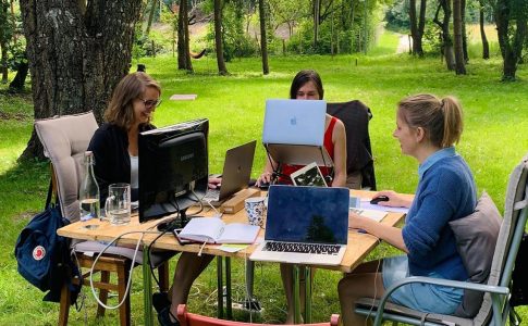 Drei Frauen arbeiten im Freien an Computern