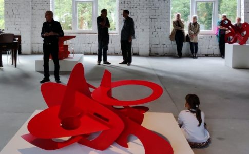 Menschen in einer Kunstausstellung in einem Raum mit weißer Ziegelsteinwand auf dem Land