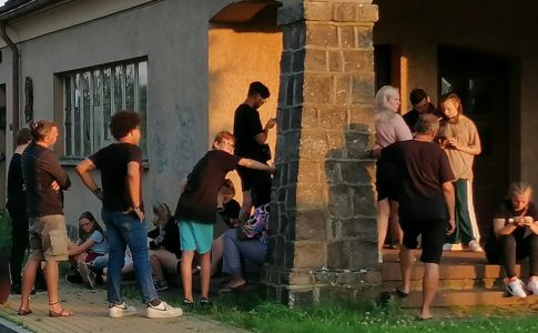 Eine Gruppe Jugendlicher vor einem historischen Gebäude nutzen Smartphones für eine Geschichtsrallye