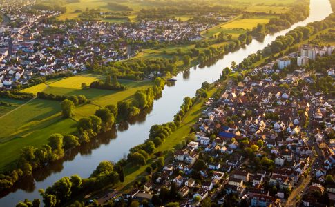 Luftansicht einer besiedelten Landschaft an einem Fluss.