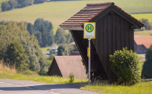 Eine Bushaltestelle an einer Straße im ländlichen Odenwald.