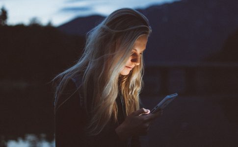 Frau guckt auf ihr Handy.