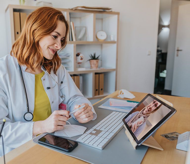 Eine Ärztin spricht per Tablet mit einer Patientin.