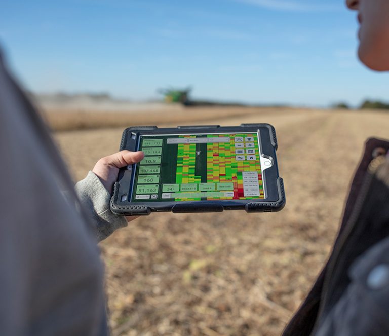 Ein Tablet mit Daten wird auf einer Wiese betrachtet.