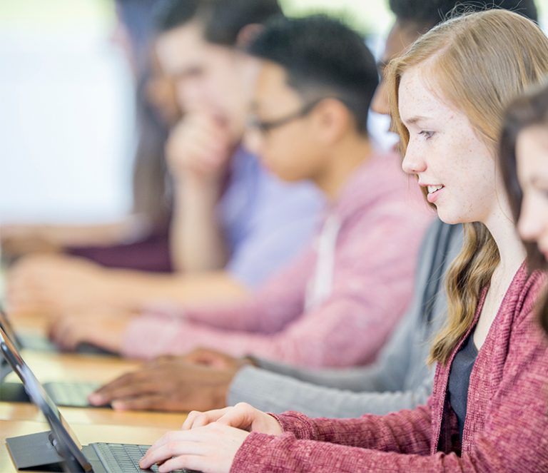 Schüler:innen arbeiten im Klassenraum mit Tablets