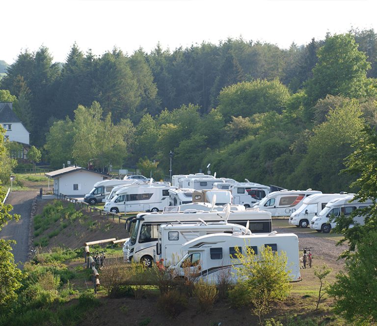 Wohnmobile auf Stellplatz in grüner Umgebung