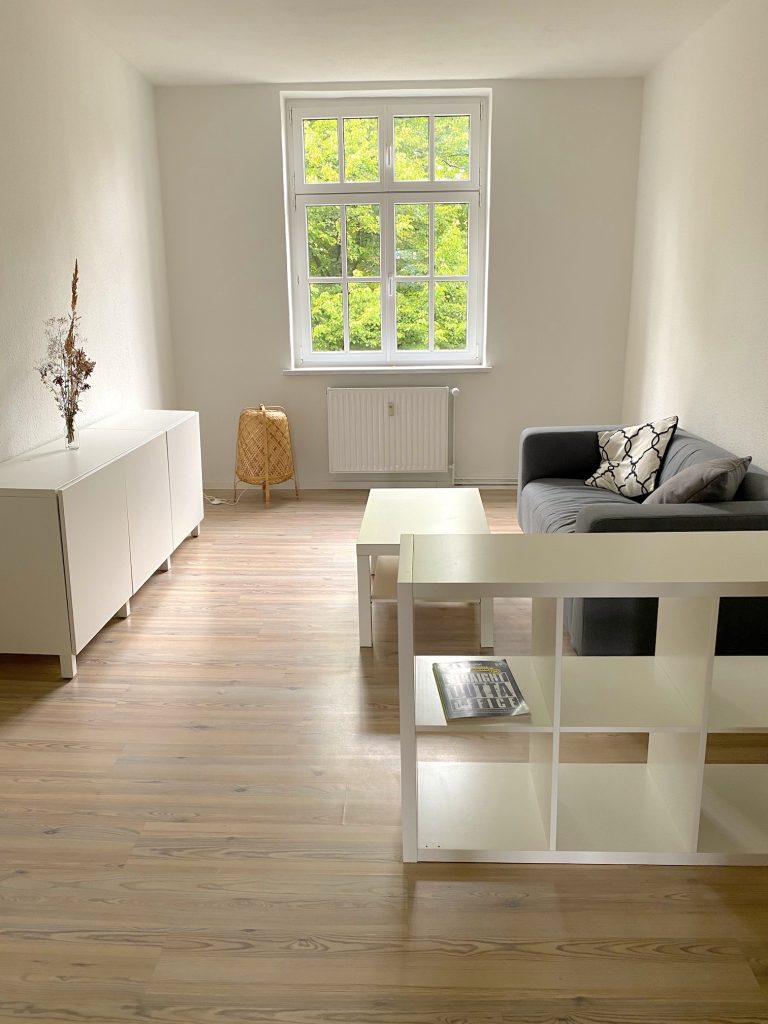 Raum mit Sofa, Regal und Sideboard mit Blick ins Grüne