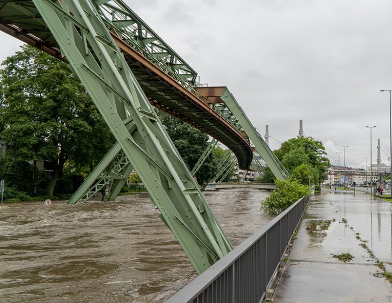 Ein Fluss mit hohem Pegelstand und überschwemmte Straße