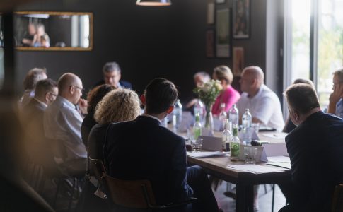 Männer und Frauen sitzen an einem Tisch