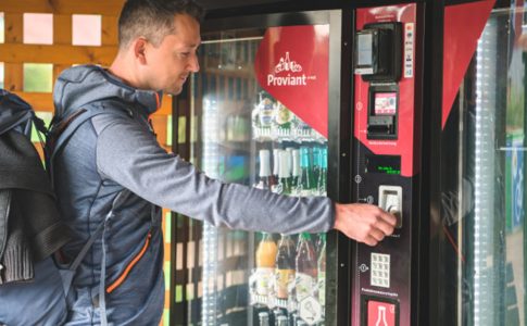 Ein Mann kauft etwas aus einem Automaten