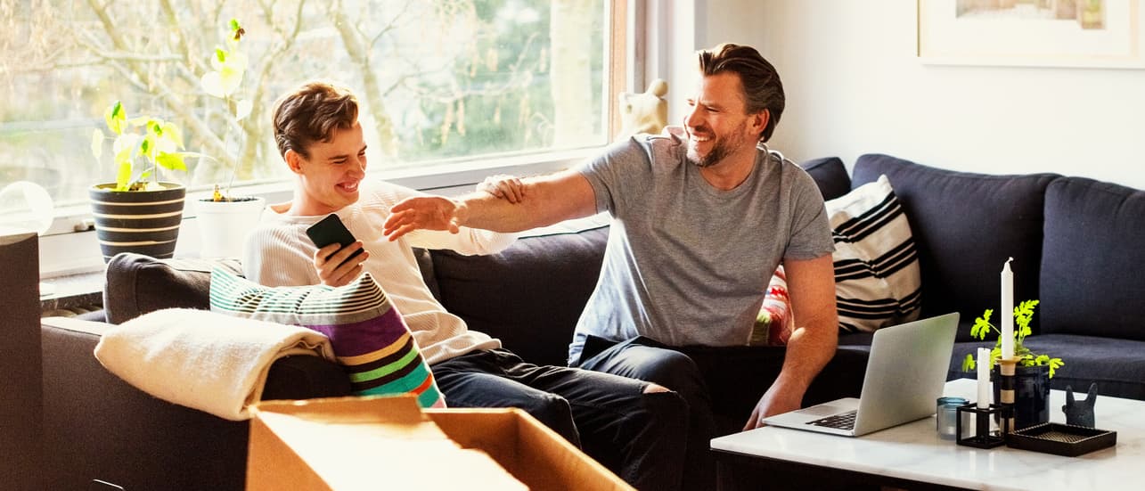 Was ist FFTH - Mann und Sohn sitzen auf der Couch und lachen zusammen